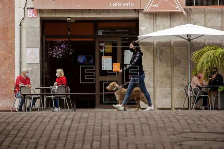 Varias personas departen en la terraza de una cafetería de Santa Cruz de Tenerife protegidos por mascarilla (Foto EFE / Ramón de la Rocha)